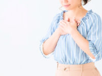 胸に手を当て安心する若い女性