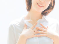 胸に手を当てヒーリングをしている若い女性