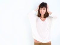 頭を抱えて落ち込む女性