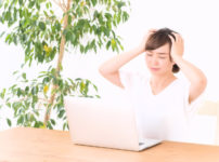 悩んで頭を抱える女性