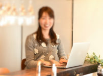 笑顔でパソコンを楽しむ清楚な女性