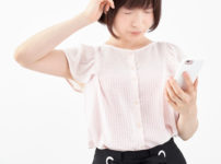 スマホを見てとても悩み困惑する女性