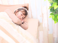 ベッドで眠る若い女性